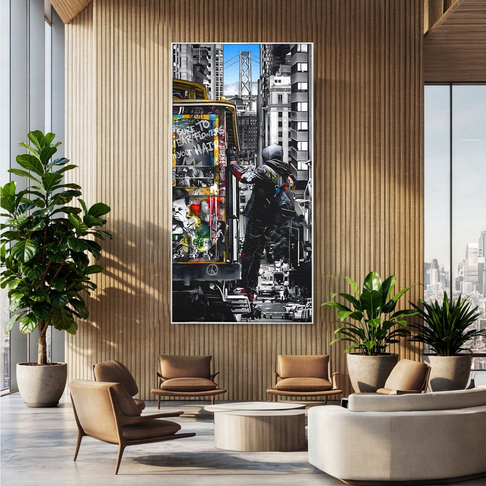Tablou canvas cu ilustratie urbana cu un tramvai si un calator, in rama de aluminiu argintiu, pe perete intr-un birou